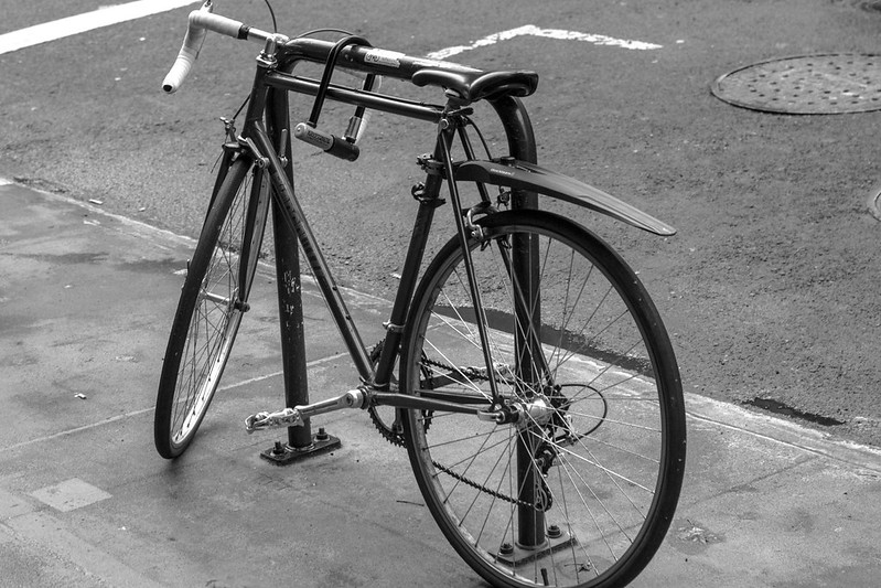 A bike, securely locked to a bike rack.